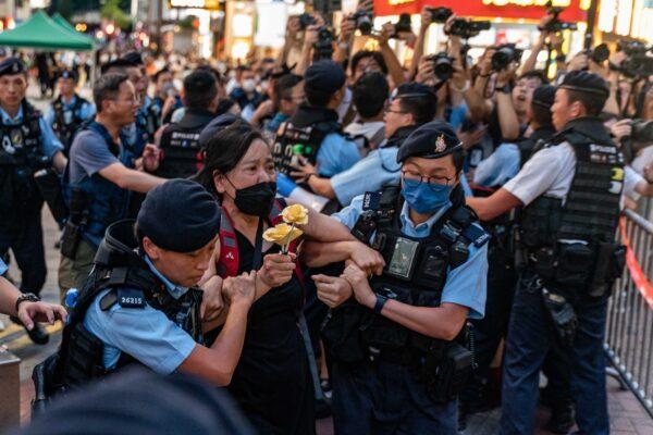 Chan Po-ying, an activist and leader of the League of Social Democrats, is detained by police officers at Causeway Bay near Victoria Park in Hong Kong on June 4, 2023. (Anthony Kwan/Getty Images)