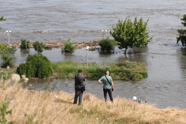 Local residents look at a partially flooded area of Kherson, Ukraine, on June 6, 2023, following the partial destruction of the Kakhovka HPP dam. The loss of the major Russian-held dam in southern Ukraine unleashed a torrent of water that forced people to flee flooding on the war's front line. (Stringer/AFP via Getty Images)