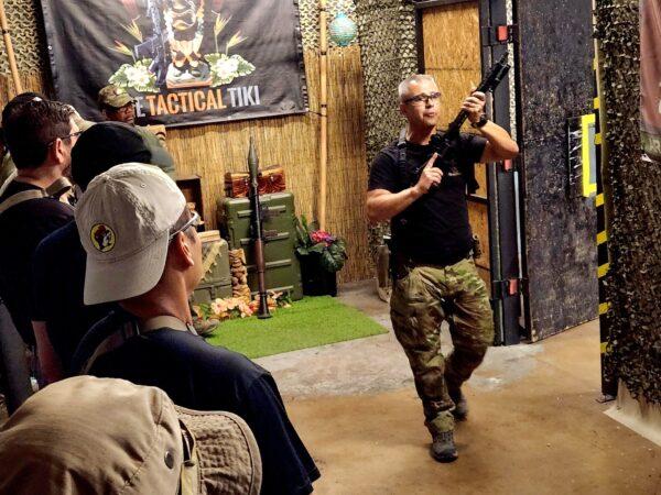Mike Simpson, director of adventures at Arizona Tactical Adventures in Phoenix, demonstrates the correct approach to a room clearing on June 3, 2023. (Allan Stein/The Epoch Times)