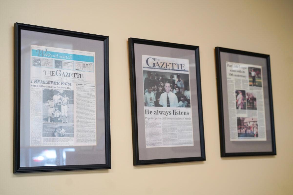 Past newspaper articles about Port Jervis School District Superintendent John Bell in his office in Port Jervis, N.Y., on May 31, 2023. (Cara Ding/The Epoch Times)