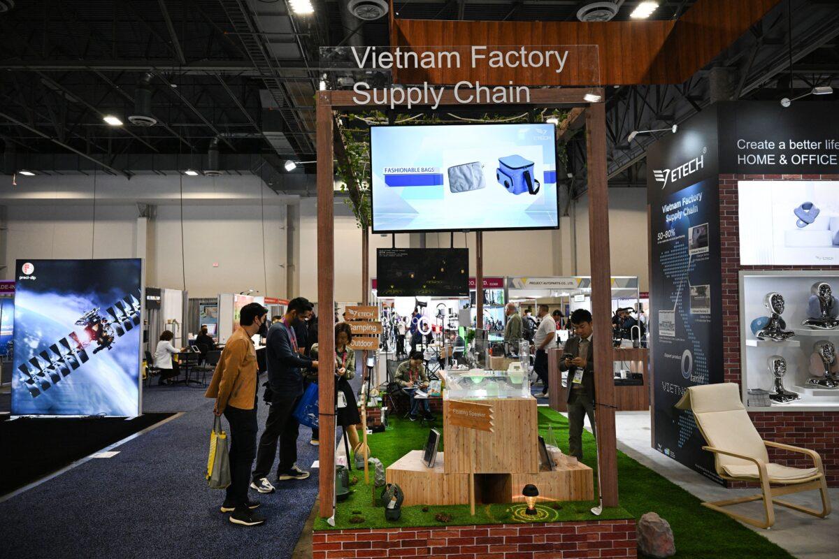 Attendees visit the ETech booth, which advertises a Vietnam factory supply chain promising zero export tariffs, during the Consumer Electronics Show (CES) in Las Vegas, Nevada, on Jan. 6, 2023. (Robyn Beck/AFP via Getty Images)