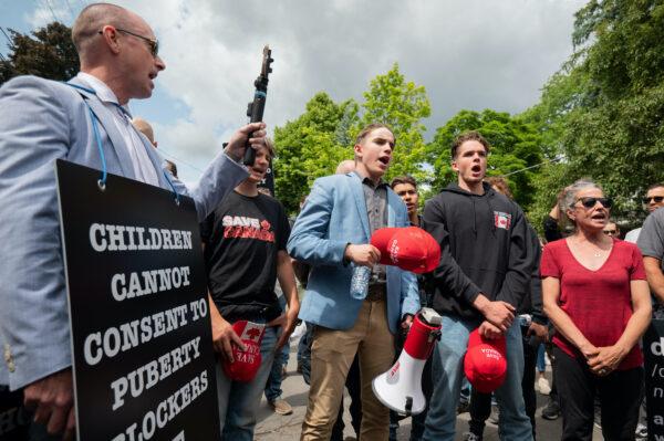 Protesters from "Save Canada" and Chris Elston (L) sing the Canadian national anthem during a protest against gender ideology in Ottawa on June 9, 2023. (The Canadian Press/Spencer Colby)