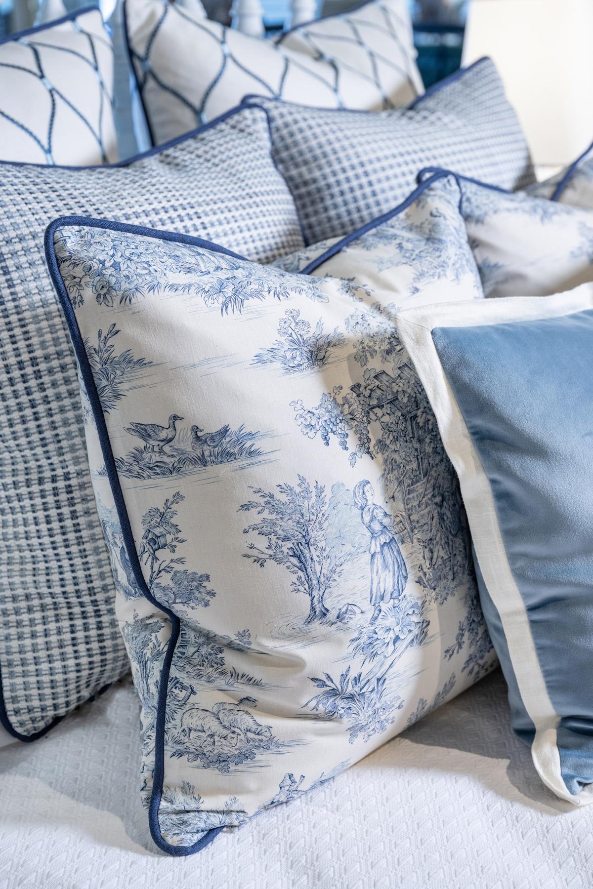 The pillows on this bedscape mix blue and white toile with similarly colored woven, embroidered, and velvet fabrics. (Handout/TNS)