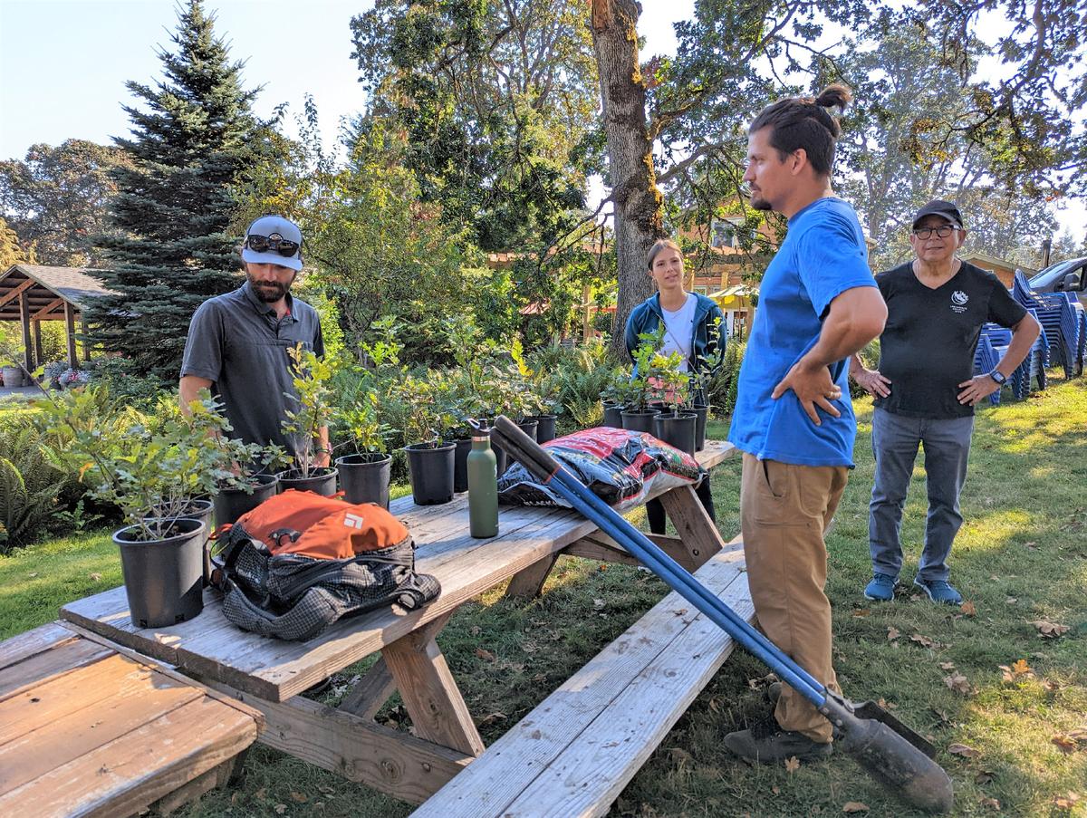 Left Coast Winery CEO Taylor Pfaff (wearing the blue T-shirt) talks with stewardship project participants as they prepare to plant white oak saplings in Rickreall, Ore. (Courtesy of Athena Lucero)