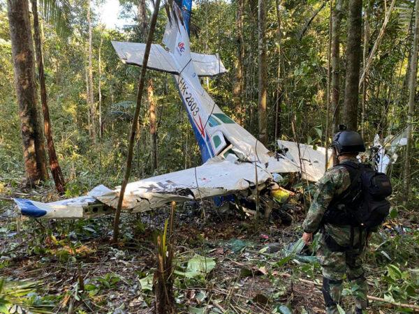 A soldier stands in front of the wreckage of a Cessna C206 that crashed in the jungle of Solano in the Caqueta state of Colombia on May 18, 2023. The discovery of footprints on May 30 of a small foot rekindled the hope of finding the children alive after their plane crashed on May 1. Soldiers found the wreckage and the bodies of three adults, including the pilot and the children's mother. (Colombia's Armed Forces Press Office via AP, File)