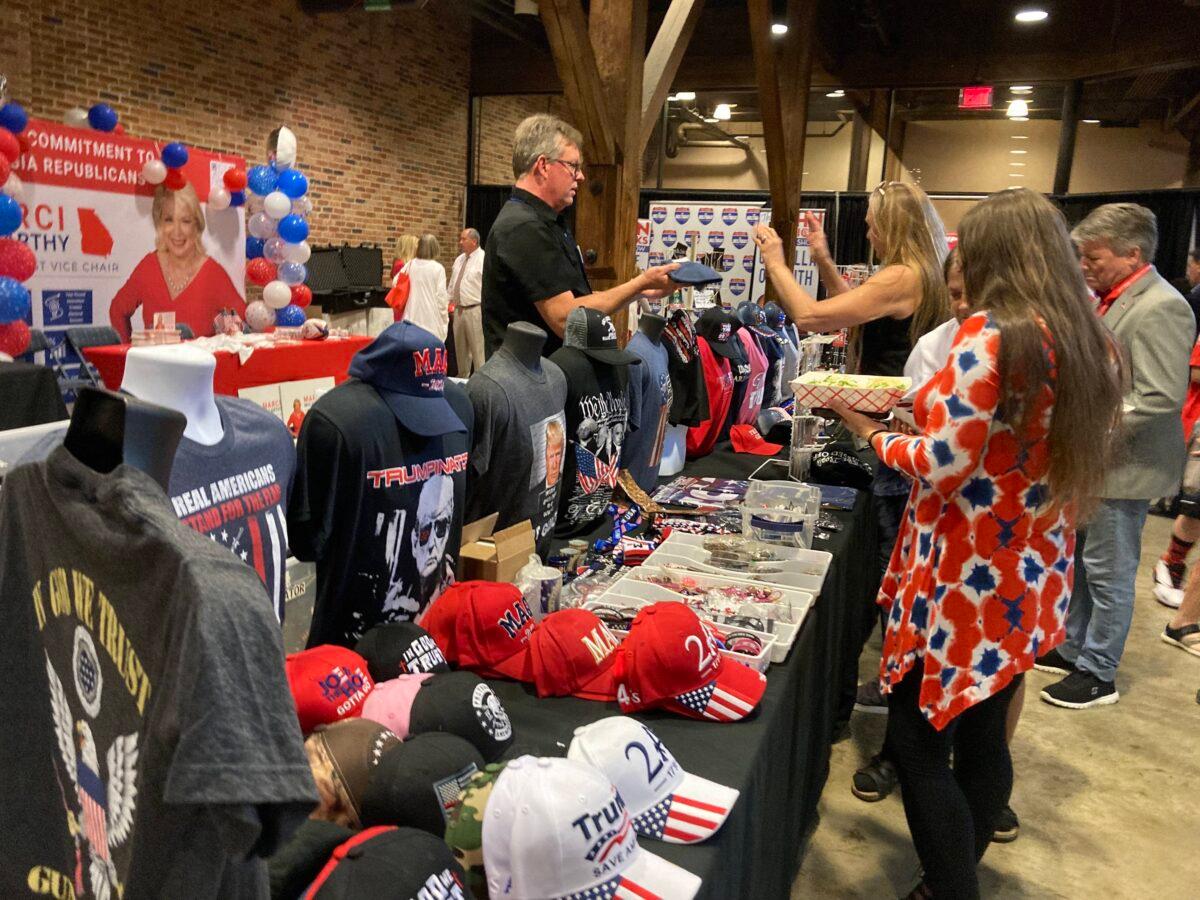 A vendor sells patriotic and Donald-Trump-themed hats and shirts at the Georgia GOP Convention in Columbus, Ga., on June 10, 2023. (Janice Hisle/The Epoch Times)