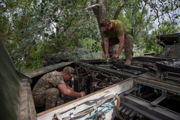 Ukrainian servicemen repair a BMP-1 infantry fighting vehicle, amid Russia's attack on Ukraine in the Donetsk region on June 11, 2023. (Oleksander Ratushniak/Reuters)