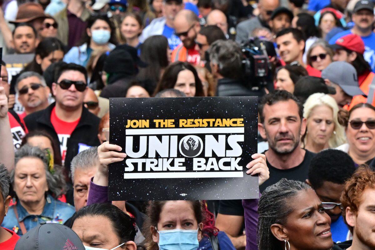 Demonstrators hold signs while picketing during the continuing strike by the Writers Guild of America (WGA) in Los Angeles on May 26, 2023. (Frederic J. Brown/AFP via Getty Images)
