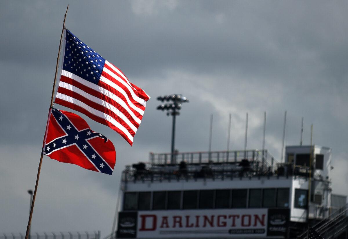A U.S. and a Confederate flag are seen flying over the infield campground before the NASCAR Sprint Cup Series Bojangles' Southern 500 at Darlington Raceway in Darlington, S.C., on Sept. 6, 2015. (Jonathan Moore/Getty Images)