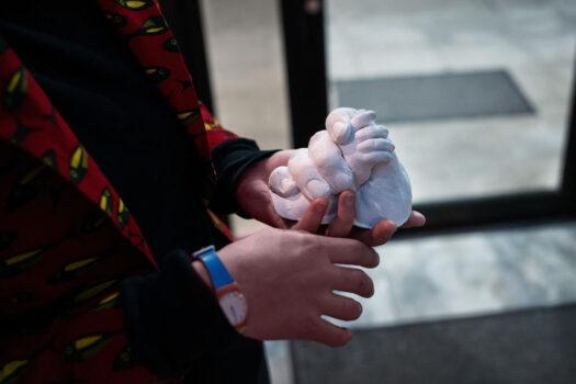 Lily Sage Weinrieb looks at a hand casting she made for a father holding the hand of his dead baby in New York City on April 27, 2020. (Misha Friedman/Getty Images)