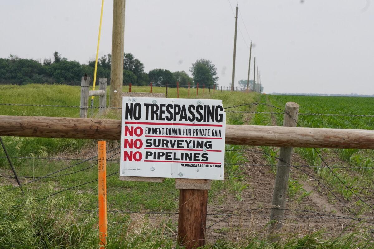 A sign near South Dakota farmer Ed Fischbach's property warns against surveyors and pipelines on June 10, 2023. (Allan Stein/The Epoch Times)