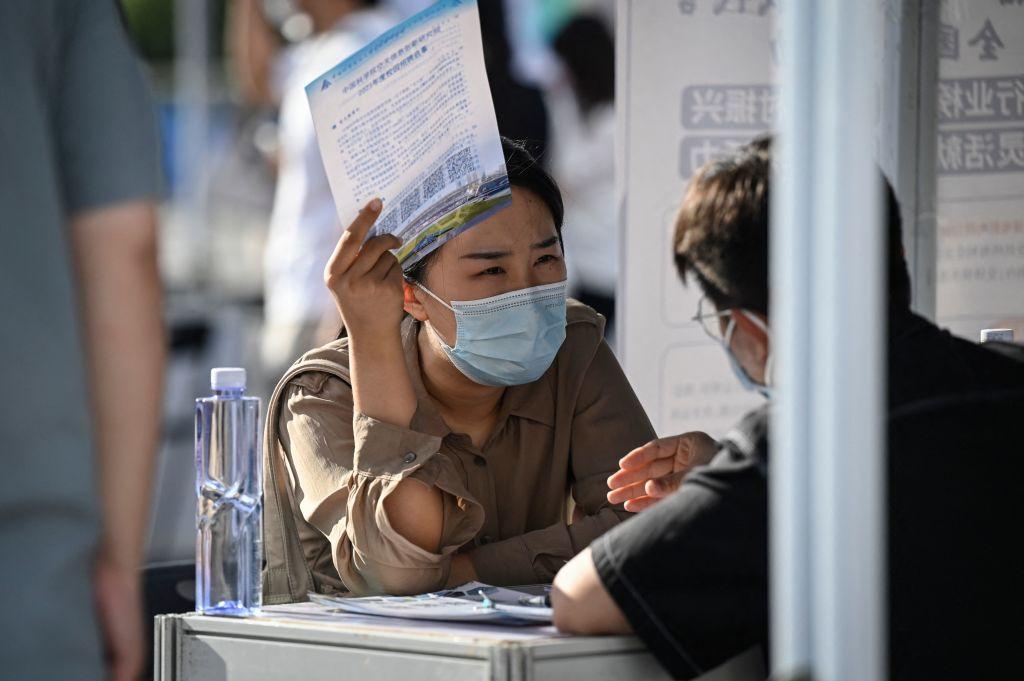 A job seeker speaks with a recruiter at a job fair in Beijing on Aug. 26, 2022. (Jade Gao/AFP via Getty Images)