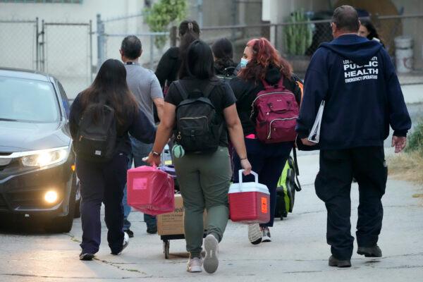 Los Angeles County Public Health Emergency Operations officials leave St. Anthony's Croatian Catholic Church after evaluating newly arrived migrants being housed in the Chinatown area of Los Angeles on June 14, 2023. (AP Photo/Damian Dovarganes)