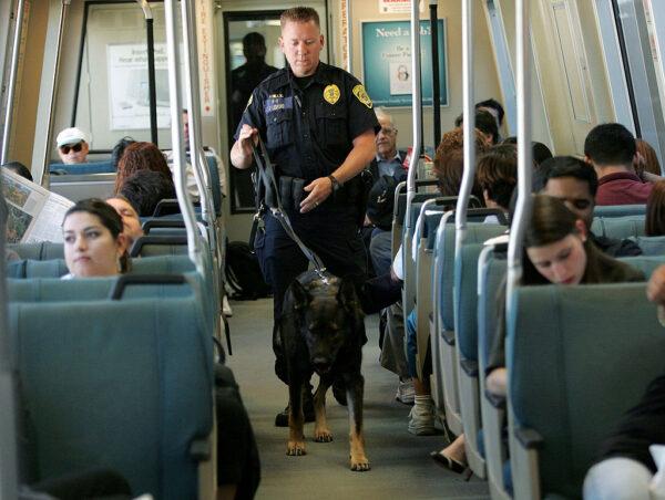A Bay Area Rapid Transit police officer patrols with his bomb-sniffing dog while aboard a BART train in Oakland, Calif., in a file photo. (Justin Sullivan/Getty Images)