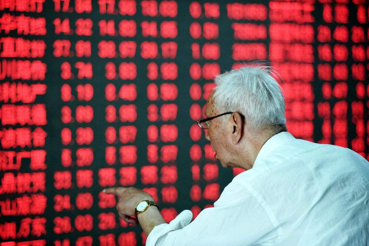 A Chinese investor gestures in front of a screen showing stock market movements at a securities firm in Hangzhou, eastern China's Zhejiang province on May 31, 2016. (STR/AFP via Getty Images)