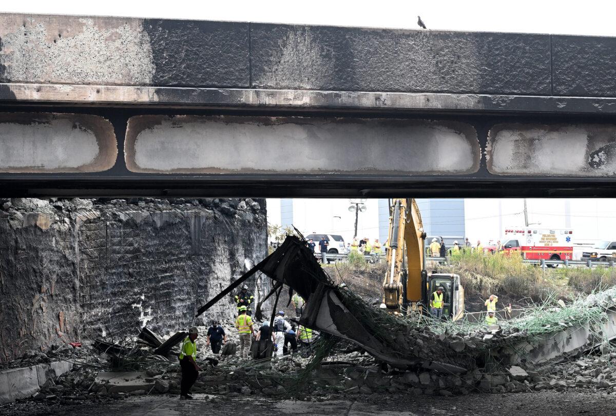 Workers inspect and clear debris from a section of the bridge that collapsed on Interstate 95 after an oil tanker explosion in Philadelphia on June 12, 2023. (Mark Makela/Getty Images)