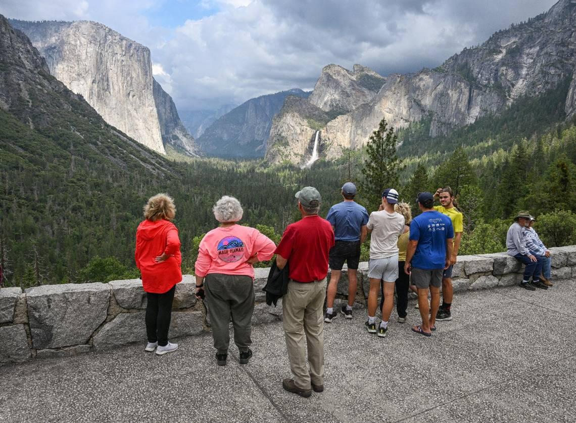 Yosemite National Park visitors take a look at El Capitan rock formation, left, and Bridalveil Fall from Tunnel View in Yosemite Valley on Tuesday, June 14, 2023. (Craig Kohlruss/The Sacramento Bee/TNS)