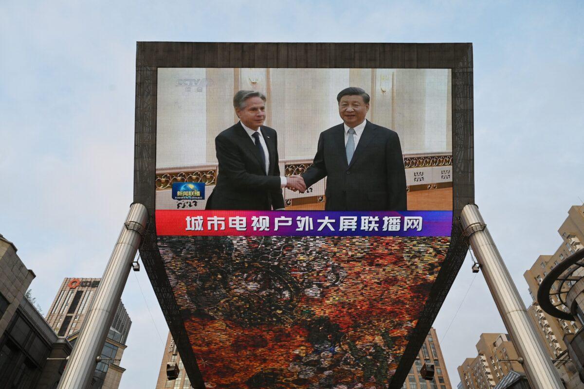 A China Central Television (CCTV) news broadcast shows footage of U.S. Secretary of State Antony Blinken (L) meeting with Chinese leader Xi Jinping, on a giant screen outside a shopping mall in Beijing on June 19, 2023. (Greg Baker/AFP via Getty Images)