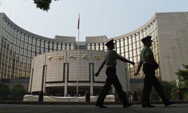  Paramilitary policemen patrol in front of the People's Bank of China, the central bank of China, in Beijing on July 8, 2015. (Greg Baker/AFP via Getty Images)