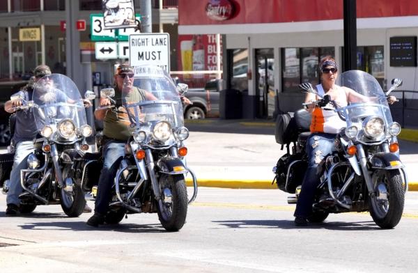 Three Harley-Davidson riders pull into downtown Sturgis, S.D., on June 17, 2023. (Allan Stein/The Epoch Times)