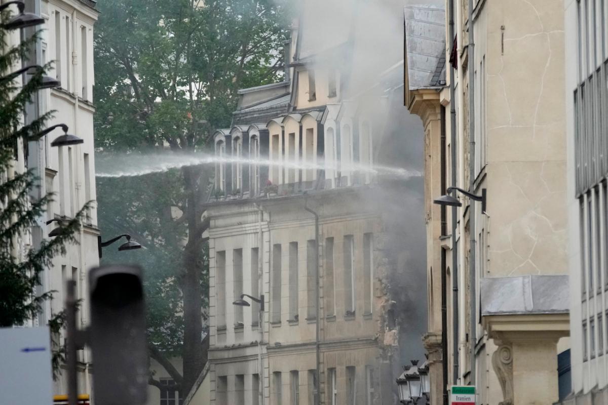 Firemen use a water canon as they fight a blaze in Paris on June 21, 2023. (Christophe Ena/AP Photo)