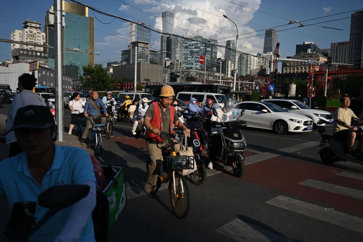 People wait to cross a street in Beijing on June 20, 2023. (Greg Baker/AFP via Getty Images)