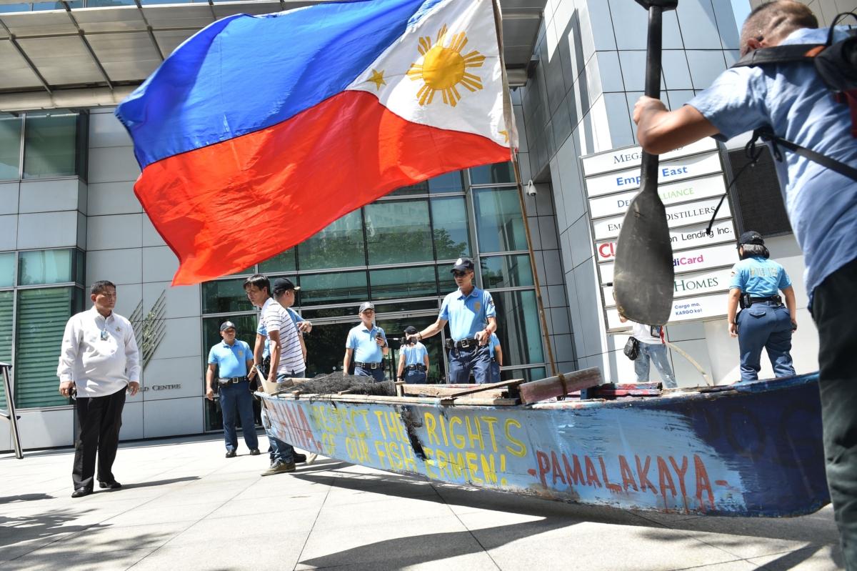 Fishermen from Masinloc town, who fish at the Scarborough Shoal, and activists carry a wooden fishing boat during a protest outside the Chinese consulate in Manila on July 12, 2016, ahead of a U.N. tribunal ruling on the legality of China's claims to an area of the South China sea contested by the Philippines. (Ted Aljibe/AFP via Getty Images)