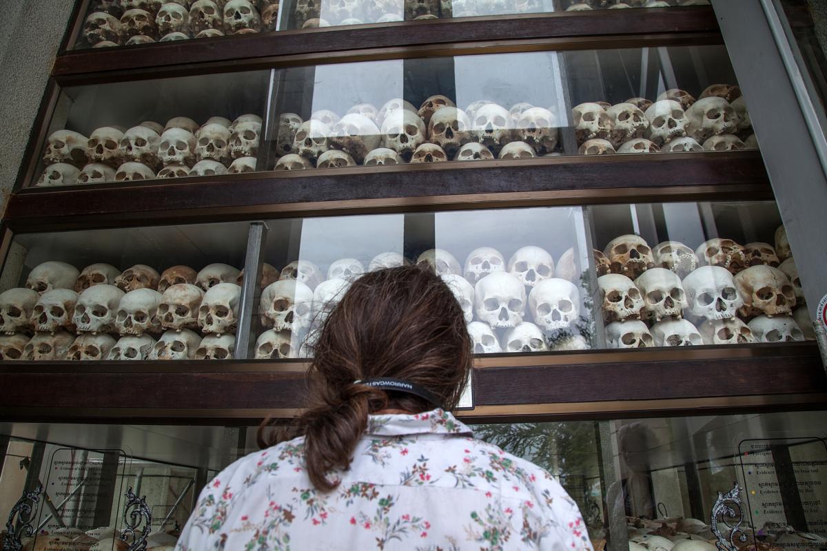 A young Cambodian woman looks at the main stupa in Choeung Ek Killing Fields, which is filled with thousands of skulls of those killed during the Pol Pot regime, in Phnom Penh, Cambodia, on Aug. 6, 2014. (Omar Havana/Getty Images)