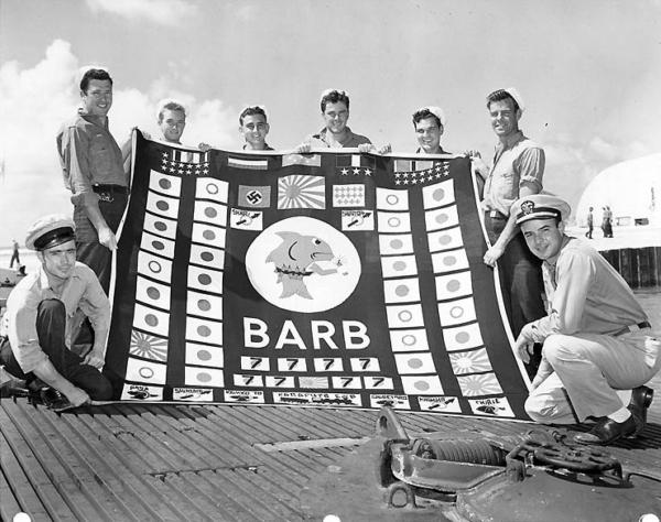Members of the submarine's demolition squad pose with her battle flag at the conclusion of her 12th war patrol. Taken at Pearl Harbor, August 1945. (Public Domain)