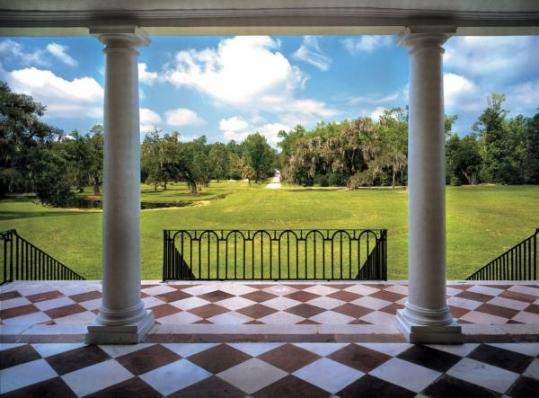 Drayton Hall’s wide marble-tiled portico with towering columns and iron railings overlooks the long entryway, once traversed by horse-drawn carriages and horses and their riders. (Drayton Hall Preservation Trust)
