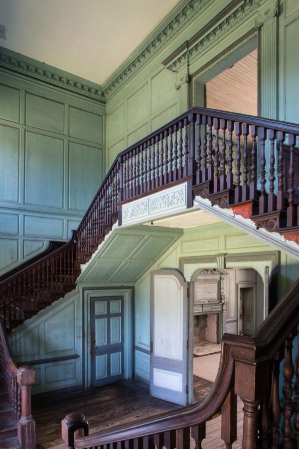 The elaborate stair hall, with routes to the first main floor and the second floor, is set off by hand-carved mahogany railings and a series of complementary paneled walls. Even a small area at the stair landing sports adornment, which indicates just how attentive the Drayton family was to the ornamental detailing of the home. (Drayton Hall Preservation Trust)