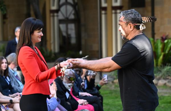 Waanyi traditional owner Alec Doomadgee (right) hands a traditional weapon to Queensland Environment Minister Leanne Linard (left) during a ceremony marking the return of more than 79,000 hectares of Boodjamulla (Lawn Hill) National Park to the land’s Traditional Owners, the Waanyi People, at Queensland Parliament House in Brisbane, June 23, 2023. (AAP Image/Darren England)
