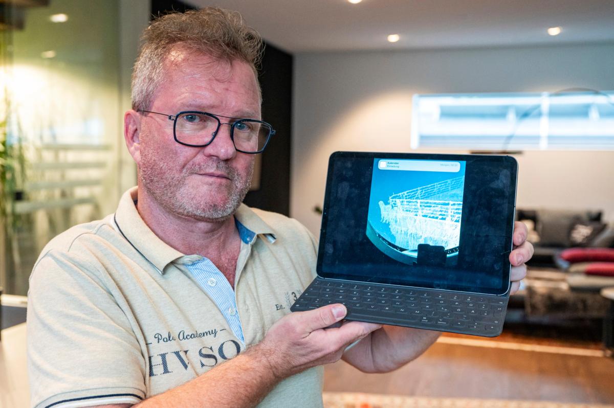 Arthur Loibl, one of the submersible company Oceangate's first customers, holds up a photo of the Titanic in Straubing, Germany, on June 21, 2023. (Armin Weigel/dpa via AP)