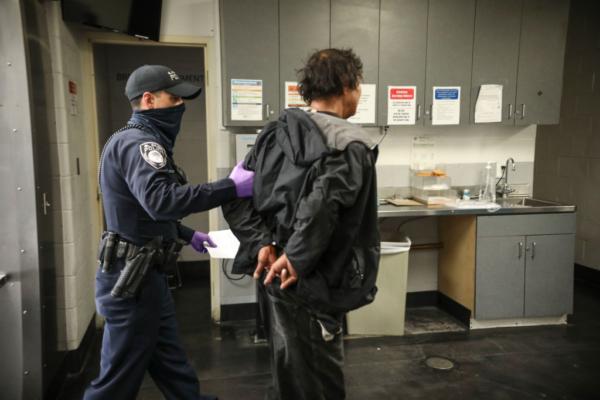 An El Cajon Police officer books a man into the San Diego County Jail in San Diego, Calif., on April 24, 2020. (Sandy Huffaker/Getty Images)