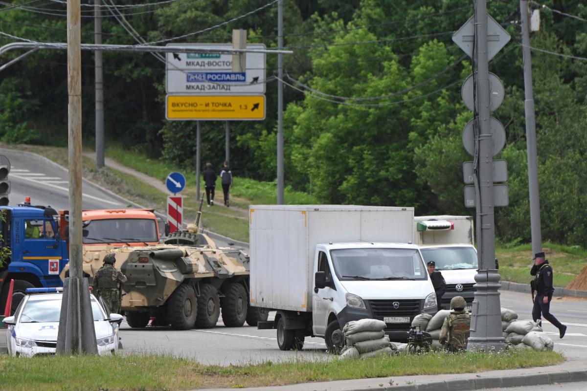 Russian army servicemen and police officers guard the highway at the entrance to Moscow on June 24, 2023. (AP Photo)