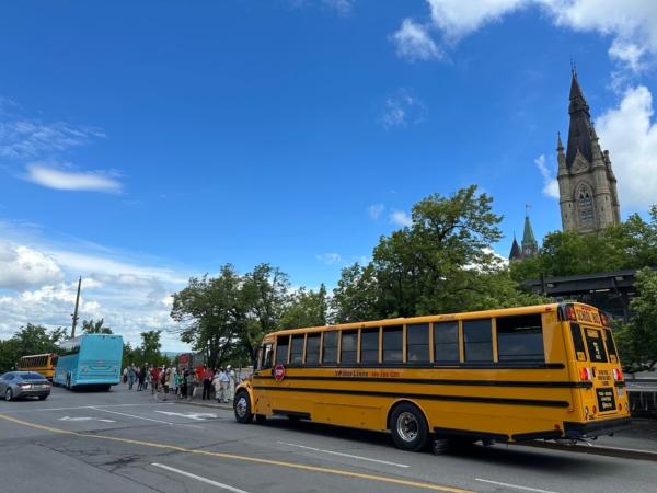 Buses arrive with protest participants in Ottawa on June 24, 2023. (The Epoch Times)