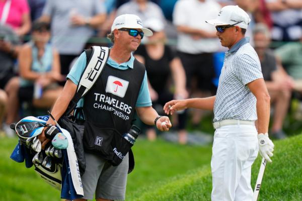 Rickie Fowler, right, talks with his caddie on the ninth green during the third round of the Travelers Championship golf tournament at TPC River Highlands, in Cromwell, Conn., on June 24, 2023. (Frank Franklin II/AP Photo)