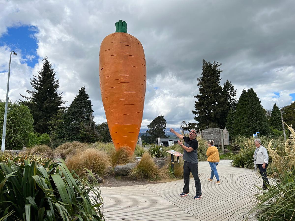 Mark Hockley of Great Journeys shows off a massive carrot sculpture, the centerpiece of Ohakune Carrot Adventure Park in Okahune. (Mary Ann Anderson/TNS)