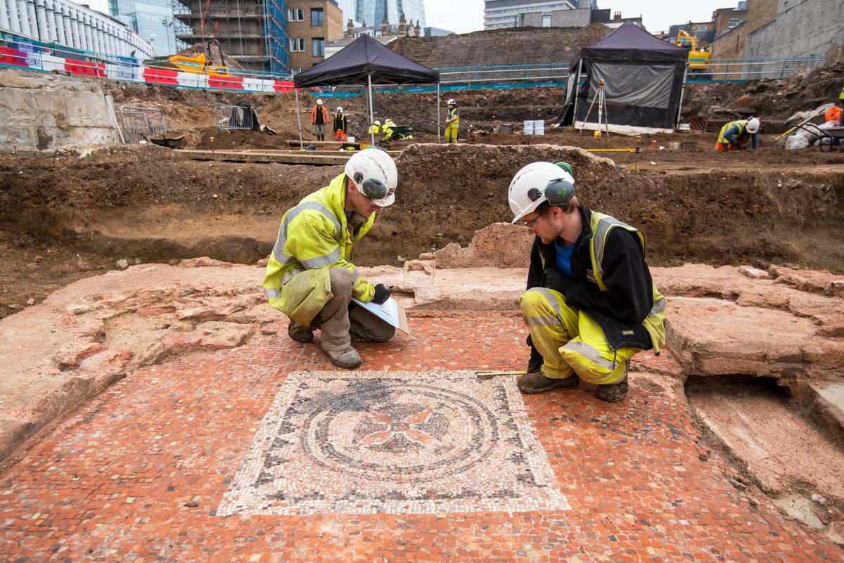 Researchers examine a raised Roman mosaic that was part of mausoleum at The Liberty of Southwark development site. (© MOLA)