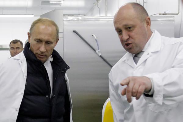 Businessman Yevgeny Prigozhin (R), nicknamed "Putin's chef" because his company Concord has catered for the Kremlin, shows Russian Prime Minister Vladimir Putin his school lunch factory outside Saint Petersburg on Sept. 20, 2010.  (Photo by ALEXEY DRUZHININ/SPUTNIK/AFP via Getty Images)