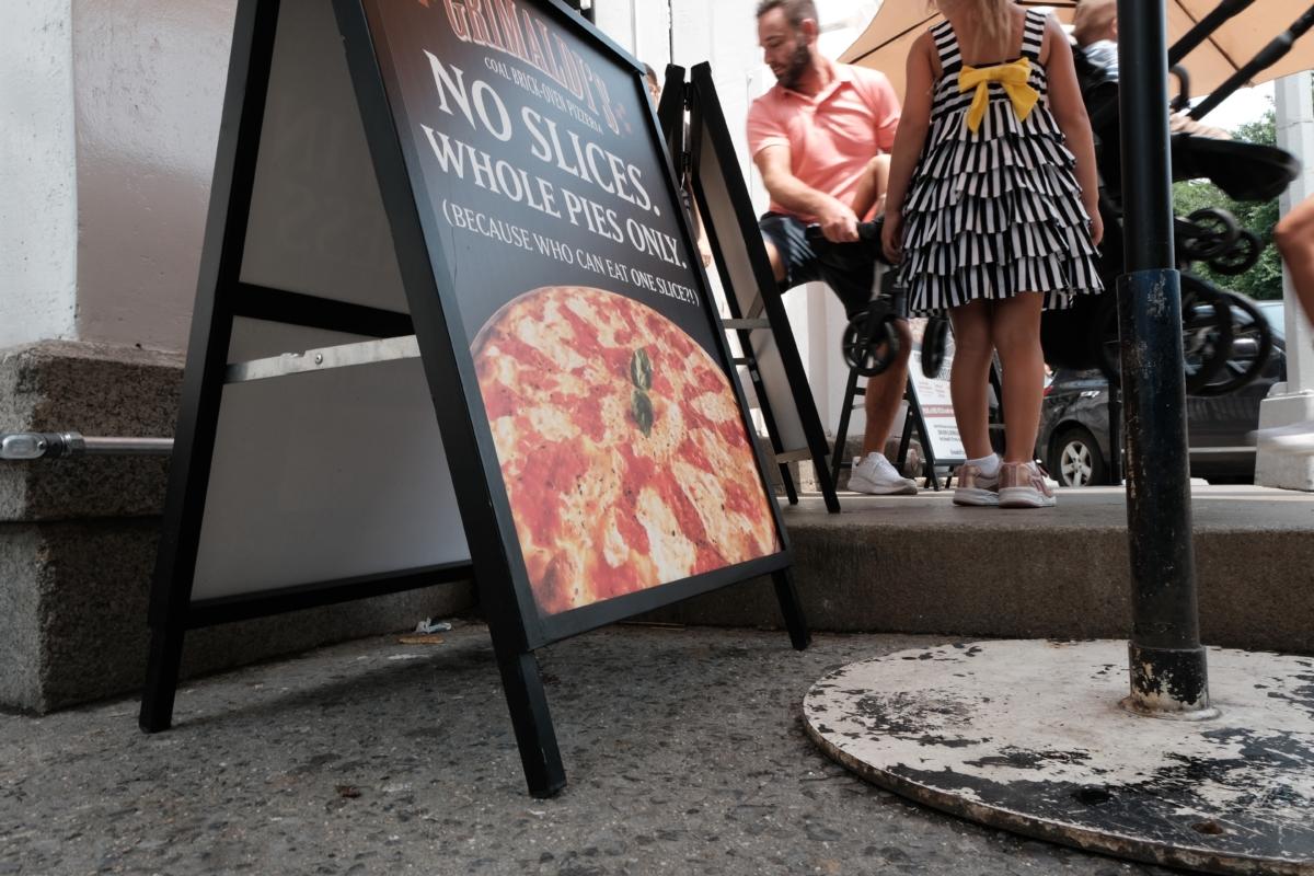 People walk outside the Brooklyn pizzeria Grimaldi's, which makes coal oven pizzas, in New York City on June 26, 2023. (Spencer Platt/Getty Images)