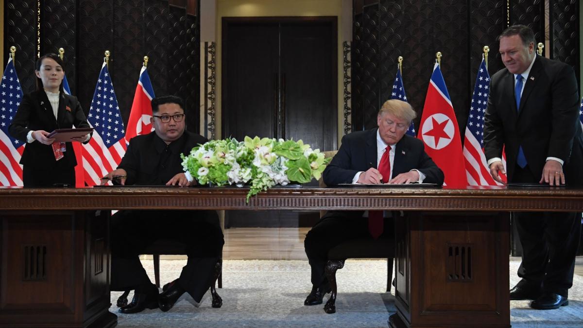 U.S. President Donald Trump (2nd R) and North Korea's leader Kim Jong Un (2nd L) sign documents as U.S. Secretary of State Mike Pompeo (R) and the North Korean leader's sister Kim Yo Jong (L) look on at a signing ceremony during their historic U.S.-North Korea summit, at the Capella Hotel on Sentosa island in Singapore on June 12, 2018. (Saul Loeb/AFP via Getty Images)