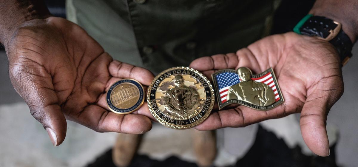 Rush displays three military challenge coins, including his own. (John Fredricks for American Essence)