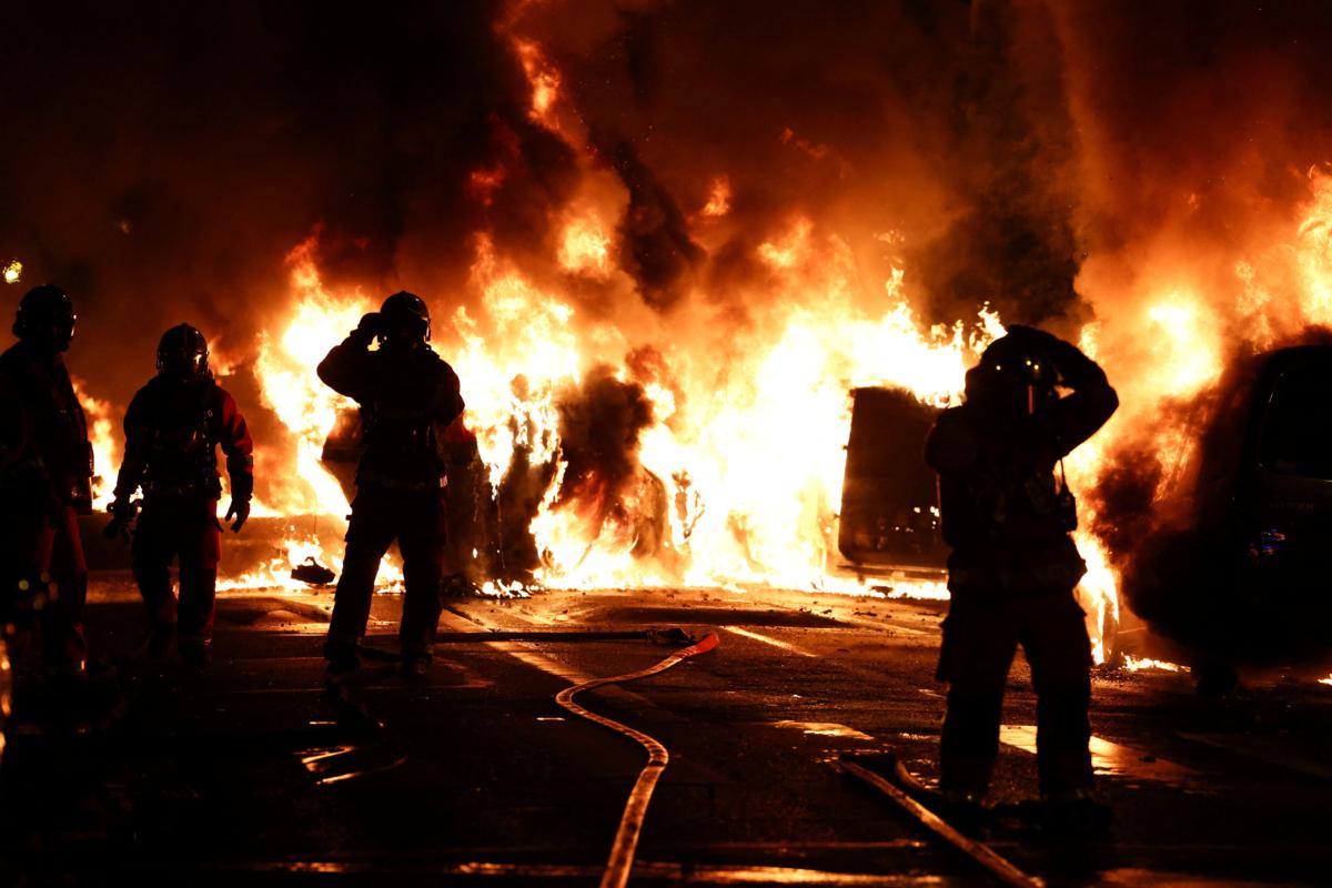 Firefighters stand as they extinguish burning vehicles during clashes between protesters and police, after the death of a 17-year-old teenager killed by a French police officer during a traffic stop in Nanterre, Paris suburb, France, on June 28, 2023. (Reuters/Stephanie Lecocq)