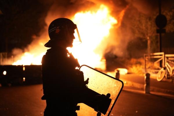 A firefighter looks on as vehicles burn following riots in Nanterre, west of Paris, on June 28, 2023. (Zakaria Abdelkafi/AFP via Getty Images)