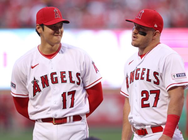 Shohei Ohtani (17) and Mike Trout (27) of the Los Angeles Angels line up for the National Anthem before the game against the Toronto Blue Jays during the 2023 home opener at Angel Stadium of Anaheim in Anaheim, Calif., on April 7, 2023. (Harry How/Getty Images)
