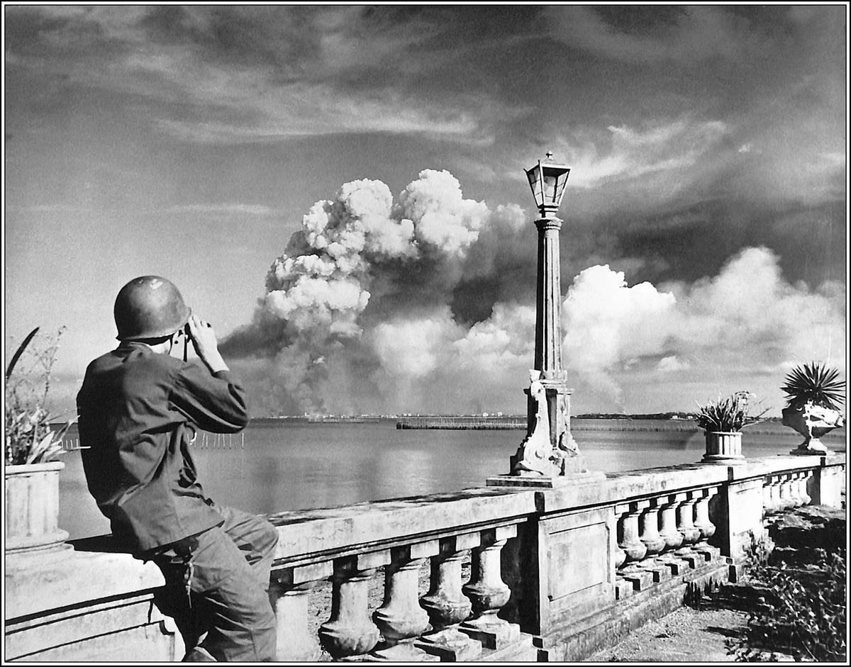 A trooper watches Manila burn from Parañaque. (<span style="font-weight: 400;">U.S. Army Archives</span>)