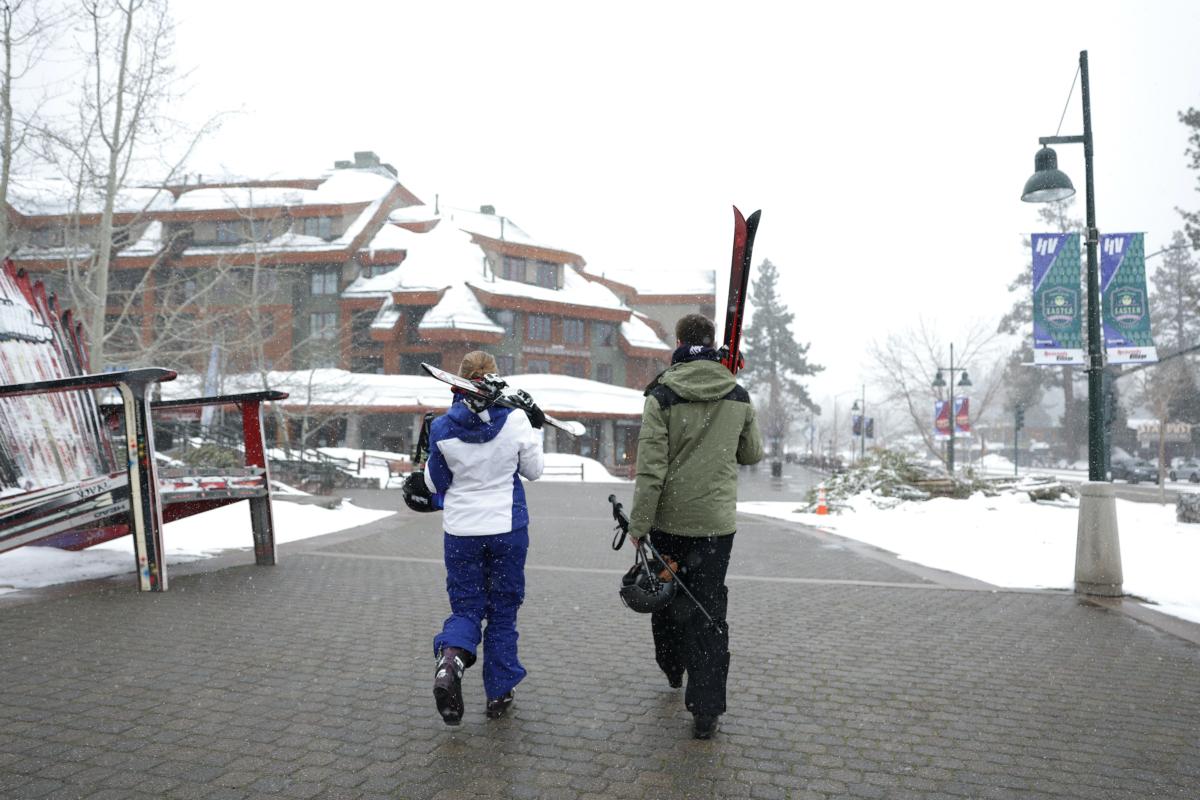 People carry skis as they walk toward a resort in South Lake Tahoe, Calif., on March 21, 2023. (Justin Sullivan/Getty Images)