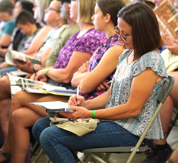 A woman takes notes during a seminar on gardening in a northern climate at The Modern Homesteading Conference in Coeur D'Alene, Idaho, on June 30, 2023