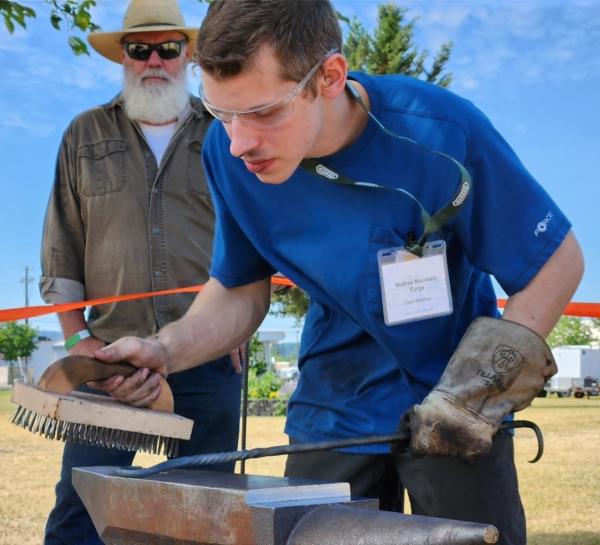 A blacksmith demonstrates how to fashion a steel tool during a conference on modern homesteading in Idaho on June 30, 2023. (Allan Stein/The Epoch Times)